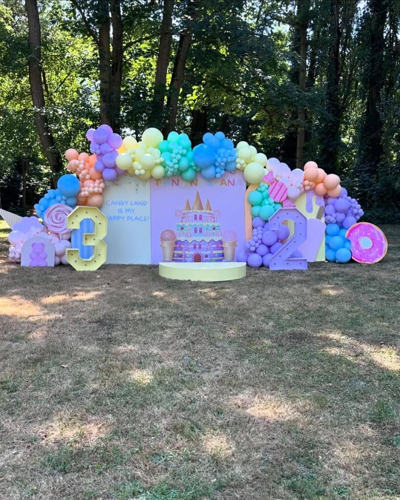 Candy Land Anniversaire : Déco Ballons '3' & '2' Décoration extérieure pour anniversaire sur le thème Candy Land avec ballons multicolores, chiffres lumineux '3' et '2', et le texte 'CANDY LAND IS MY HAPPY PLACE!' pour TANN NANA.