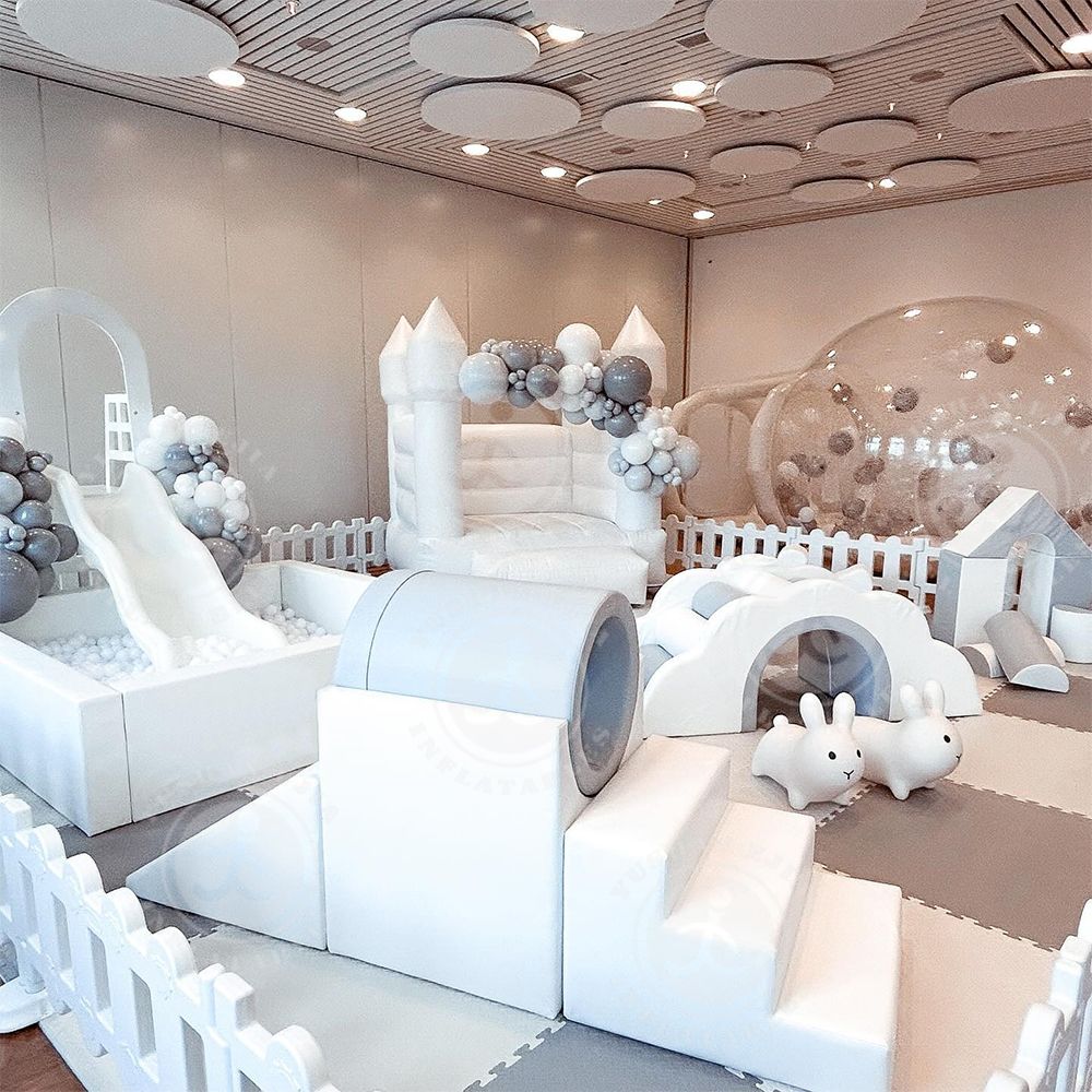 Aire de Jeux Douce Luxe | Château Gonflable Blanc pour Fête. Luxueuse aire de jeux douce blanche et grise pour anniversaire: château gonflable, piscine à balles, toboggan, tunnel et ballons.