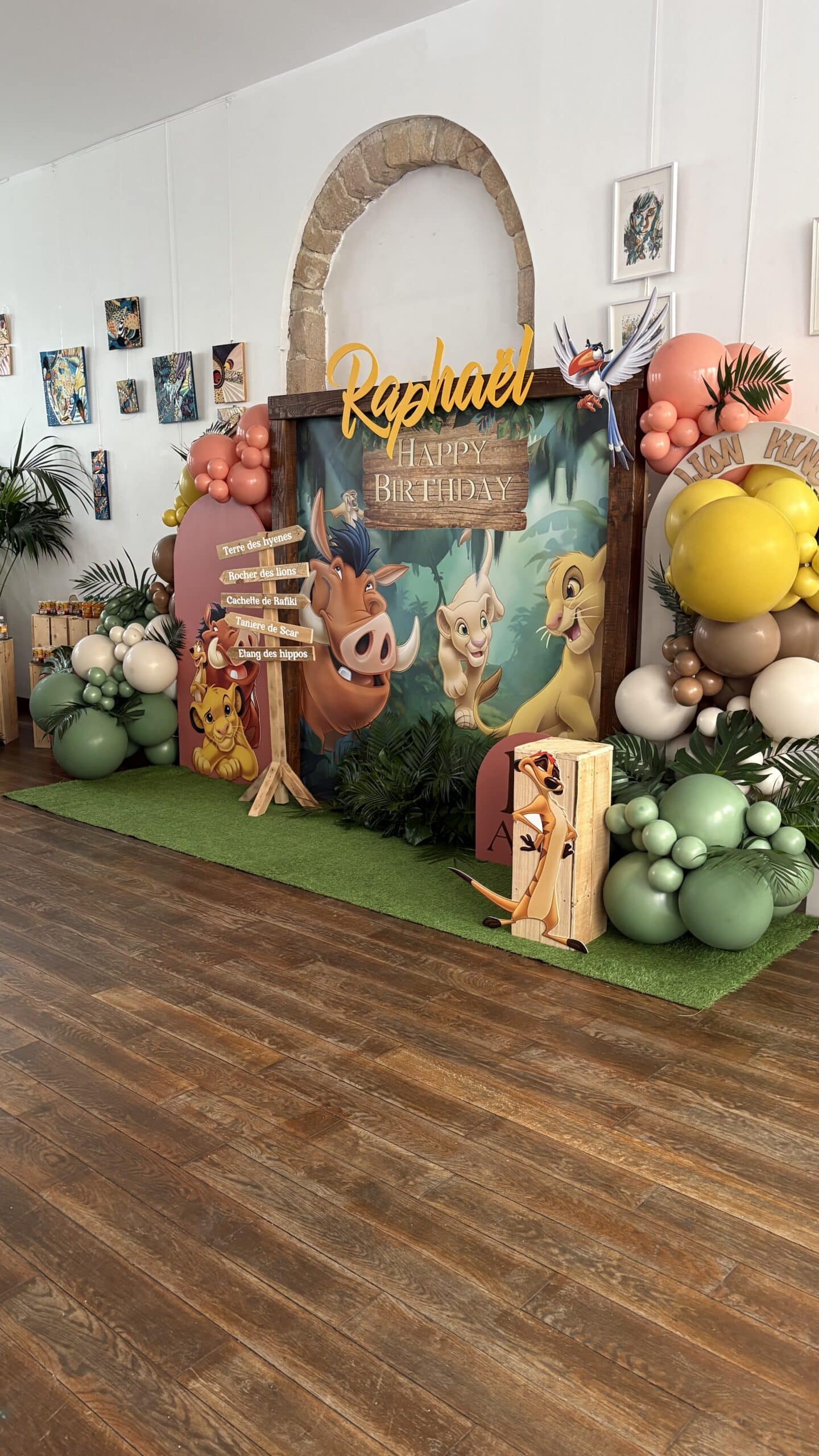 Décoration d'anniversaire Le Roi Lion, thème jungle, pour Raphaël. Backdrop avec Pumbaa, Simba, Nala. Ballons et panneau "Happy Birthday".