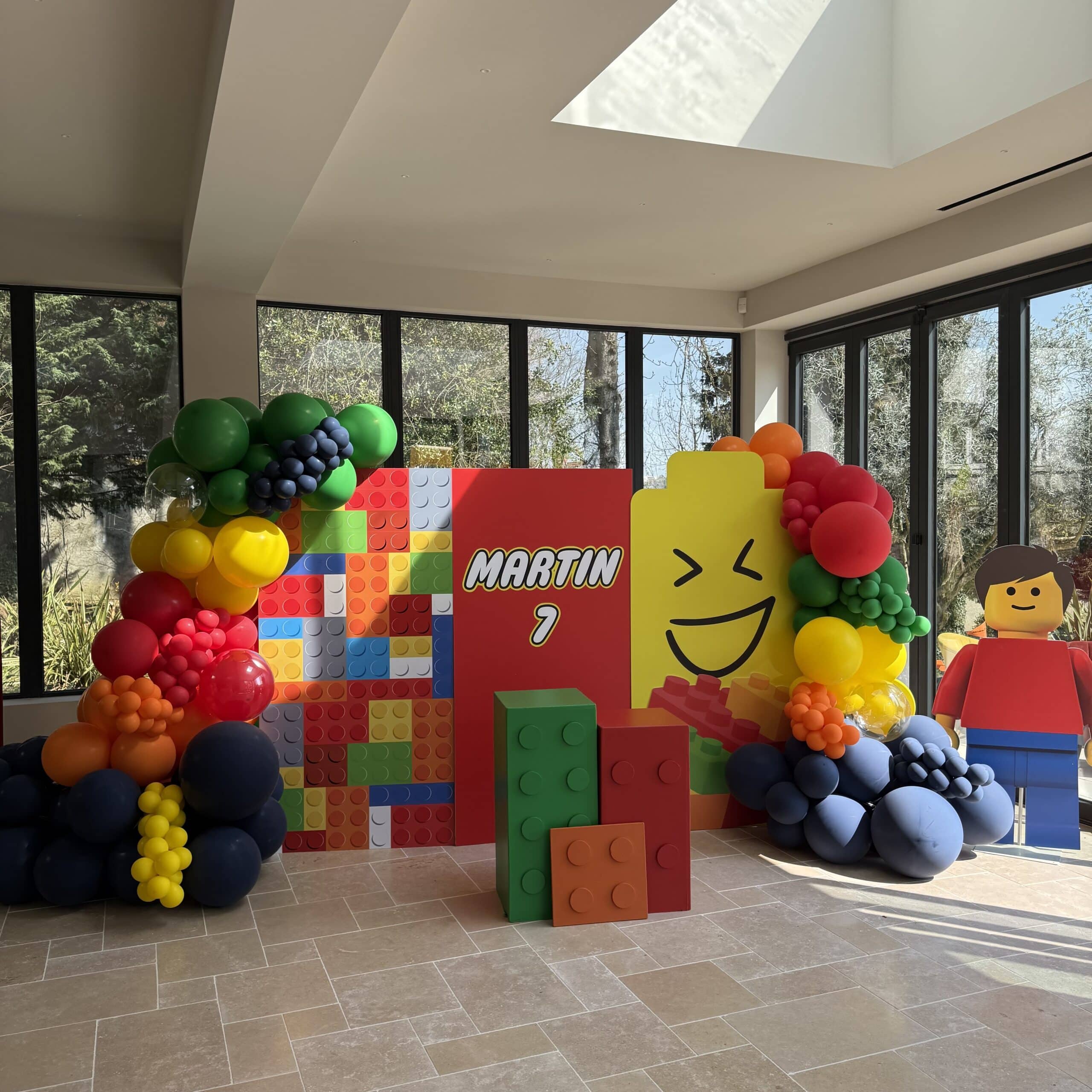 Décoration Anniversaire LEGO Martin 7 ans : Couleurs et Joie Décoration d'anniversaire LEGO pour Martin, 7 ans : ballons colorés, briques géantes et figurine souriante.